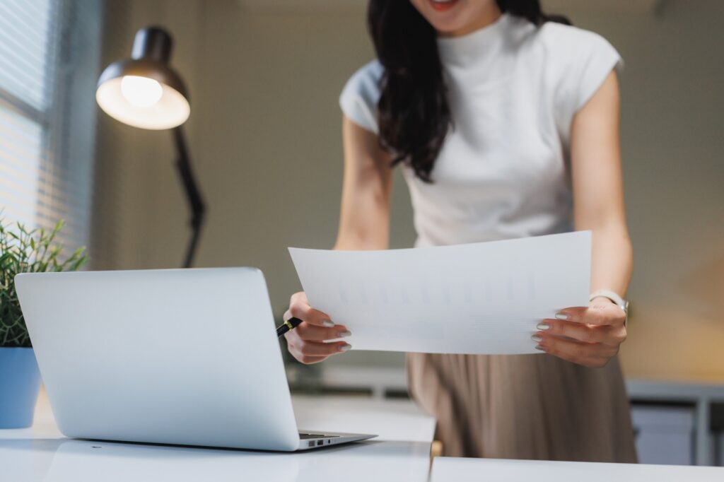 Woman Reviewing Document Standing In Office